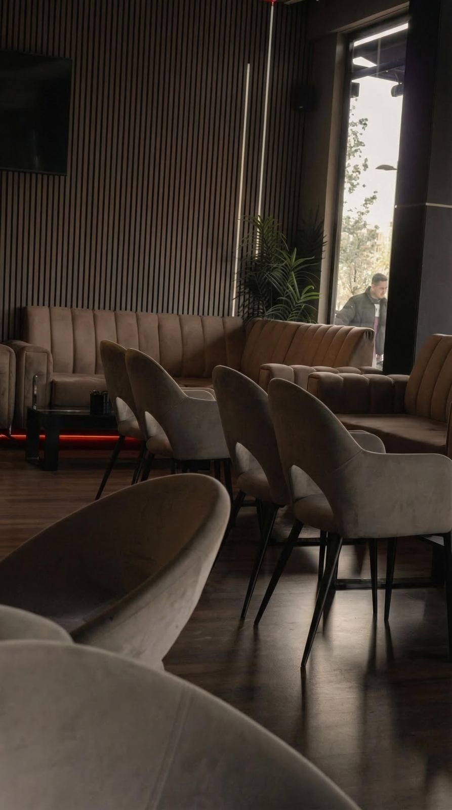 Sofás de terciopelo y madera cálida en el salón de Horizonte Lounge, Getafe